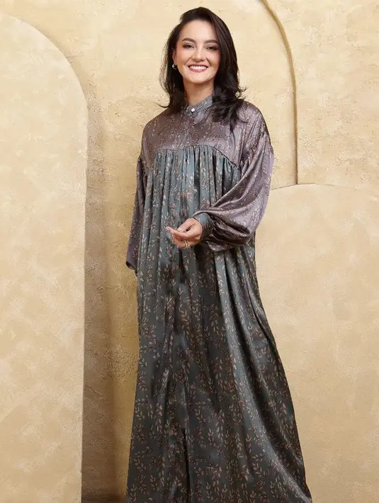 Ririn Ekawati tampil dengan gamis warna ungu pada bagian atas dan hijau bagian bawah, memiliki motif daun coklat. [@ririnekawati]