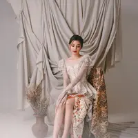 Mikha Tambayong kenakan kebaya modifikasi yang apik. Bagian atasnya dipenuhi renda, bordir, dan payet putih. Dipadukan dengan kain batik warna cream. [Instagram/miktambayong]