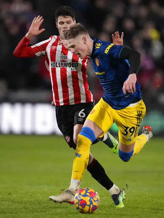 Pemain Manchester United Scott McTominay (kanan) menggiring bola melewati pemain Brentford Christian Norgaard pada pertandingan sepak bola Liga Inggris di Brentford Community Stadium, London, 19 Januari 2022. Manchester United menang 3-1. (AP Photo/Matt Dunham)
