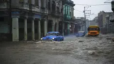 Mobil dan bus tua Amerika Serikat melewati jalan yang banjir di Havana, Kuba, 30 Juni 2021. Hujan deras dan selokan yang tidak berfungsi menyebabkan banjir di jalan-jalan di Havana. (YAMIL LAGE/AFP)