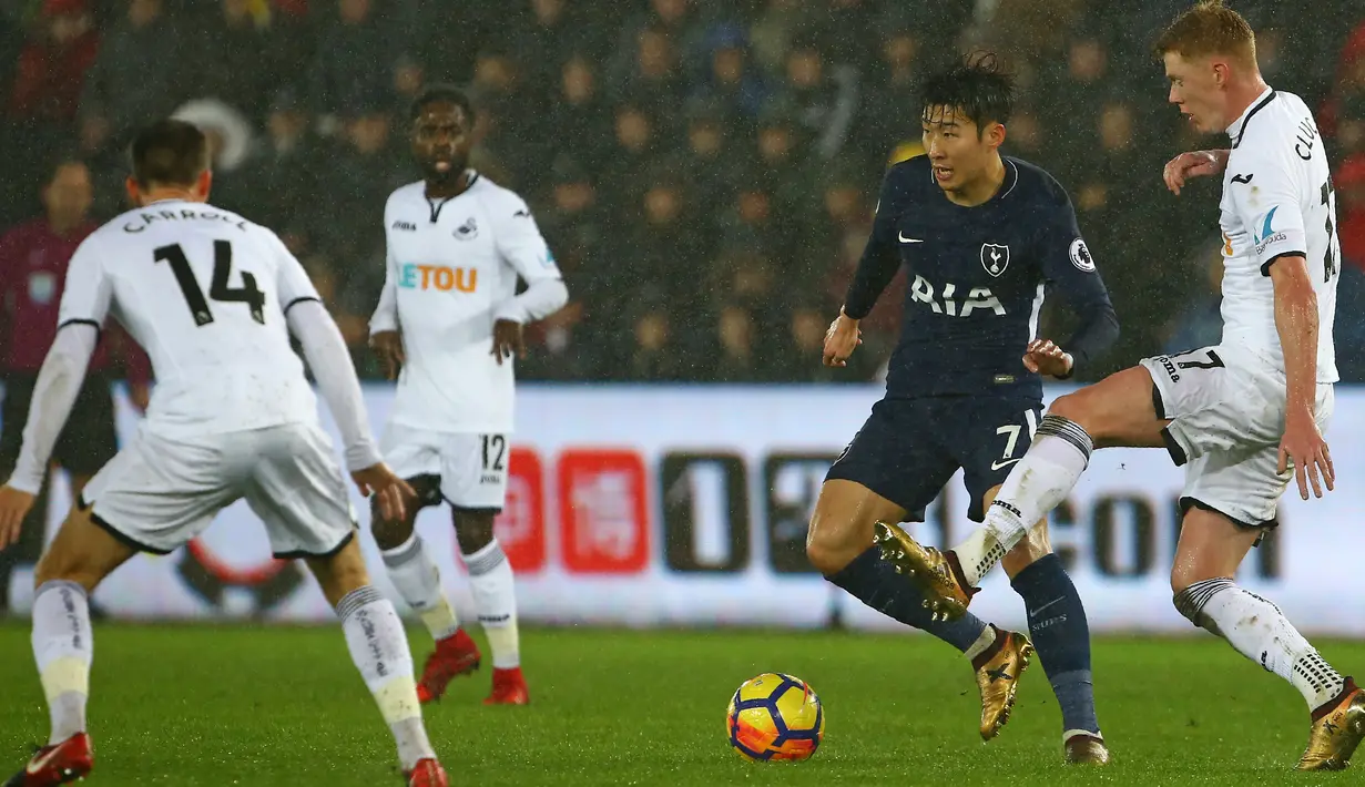 Striker Tottenham Hotspur, Son Heung Min berebut bola dengan gelandang Swansea City, Sam Clucas pada laga pekan ke-22 Premier League di Stadion Liberty, Selasa (2/1). Tottenham Hotspur mengamankan kemenangan 0-2 atas Swansea City. (Geoff CADDICK / AFP)