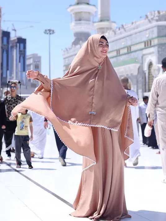 Seperti ini contohnya, Kartika memakai gamis  dengan kerudung syar’I yang warnanya senada. Kulit putihnya  makin terlihat merona dengan baju outfit berwarna cokelat ini. (Instagram/kartikaputriworld)