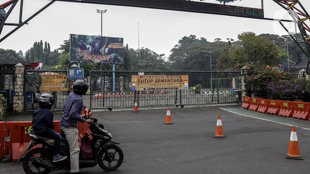 Pengendara sepeda motor berhenti di Taman Margasatwa Ragunan, Jakarta, Sabtu (26/6/2021). Taman Margasatwa Ragunan (TMR) di Jakarta Selatan mulai dibuka untuk umum usai ditutup sementara pada PPKM Mikro terkait melonjaknya kasus COVID-19 di Jakarta. (Liputan6.com/Johan Tallo)