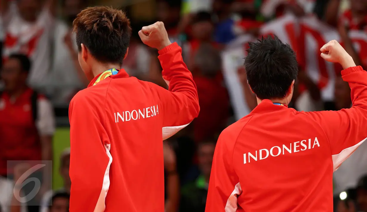 Pasangan ganda campuran Indonesia, Tontowi Ahmad dan Liliyana Natsir mengepalkan tangan saat meraih medali emas usai mengalahkan lawannya asal Malaysia Peng Soon Chan dan Liu Ying Goh pada final bulutangkis di, Brasil. (REUTERS/Mike Blake)