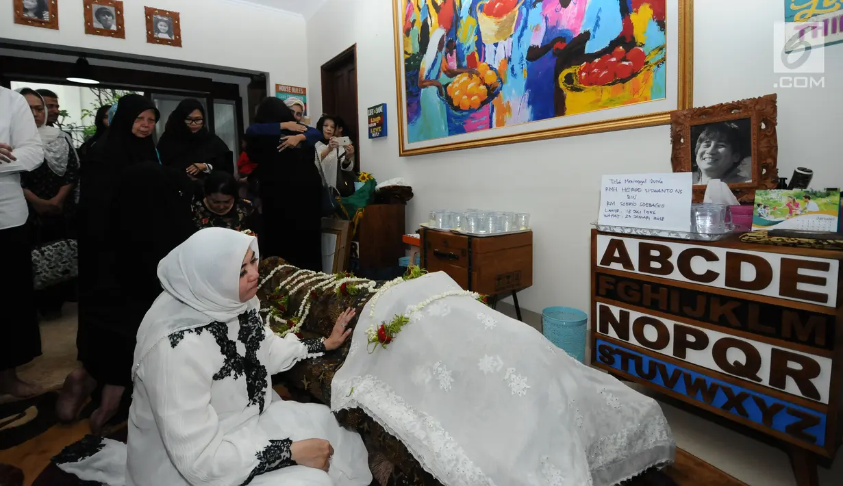 Istri alm RMH Heroe Siswanto NS atau dikenal Sys NS, Shanty Widhiyanti berdoa di sisi jenazah di rumah duka, Jakarta, Selasa (23/1). Sys NS wafat diusia 61 tahun akibat serangan jantung. (Liputan6.com/Helmi Fithriansyah)