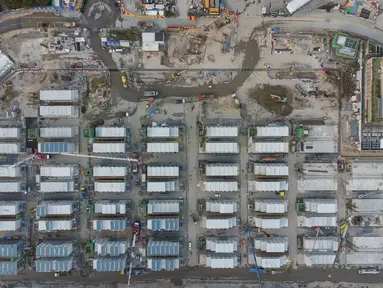 Foto udara menunjukkan lokasi pembangunan fasilitas isolasi sementara untuk menampung pasien Covid-19 yang sedang dibangun di Terminal Kapal Pesiar Kai Tak, Hong Kong (6/4/2022). Bangunan tersebut akan berisi 1.000 tempat tidur dan diharapkan bisa mengurangi beban di rumah sakit umum. (AFP/Yan Zhao)