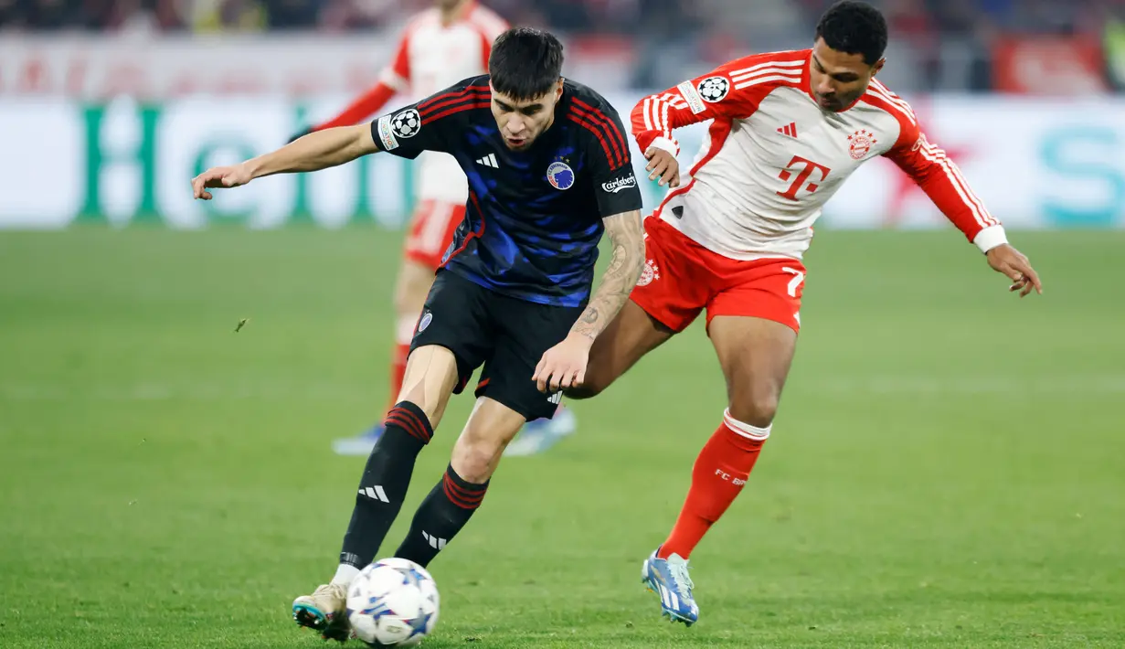 Pemain FC Copenhagen, Kevin Diks, berebut bola dengan pemain Bayern Munchen, Serge Gnabry, pada laga Liga Champions (20/11/2023). Darah Indonesia Kevin Diks mengalir dari ibunya yang bernama Natasja Diks-Bakarbessy yang keturunan Ambon, Maluku. (AFP/Michaela Rehle)