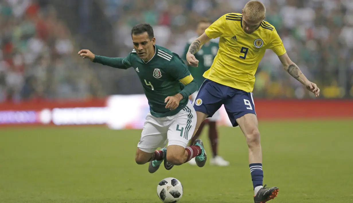 Pemain Meksiko, Rafael Marquez (kiri) saat berebut bola dengan pemain Skotlandia, Oliver McBurnie pada laga uji coba di Azteca Stadium, Meksiko City, (2/6/2018). Meksiko menang 1-0.  (AP/Rebecca Blackwell)