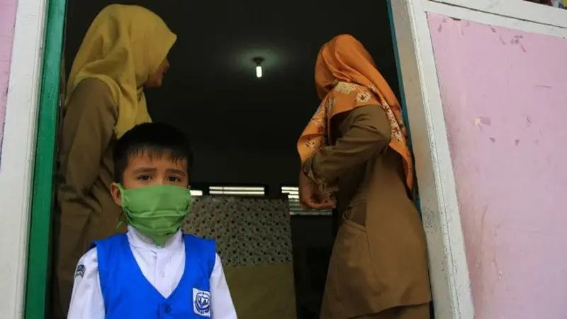 Anak TK di Pekanbaru memakai masker karena kabut asap makin parah.