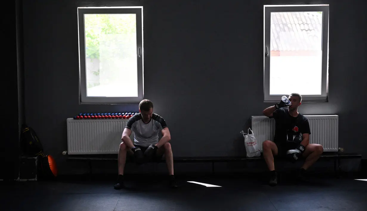 Petinju amatir beristirahat setelah sesi latihan di All Stars Boxing Club, Kiev, Ukraina, 10 Mei 2022. Suara hip hop bercampur dengan bunyi pukulan tinju saat sekelompok petinju melepaskan stres terpendam di tengah perang Ukraina. (Sergei SUPINSKY/AFP)