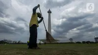 Petugas membersihkan rumput di kawasan Monumen Nasional (Monas) yang akan dijadikan arena lintasan balapan Formula E 2020, Jakarta, Selasa (11/2/2020). Pemerintah Provinsi DKI Jakarta akan menggelar ajang bertaraf internasional Formula E di kawasan Monas, Jakarta Pusat. (merdeka.com/Imam Buhori)