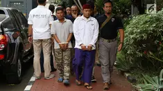 Petugas membawa dua terduga pelaku persekusi U dan M di Polda Metro Jaya, Jakarta, Jumat (2/6). Reskrim Polres Jaktim menangkap dua pelaku persekusi terhadap PMA, 15 tahun, karena diduga menghina FPI dan Rizieq Syihab. (Liputan6.com/Immanuel Antonius)