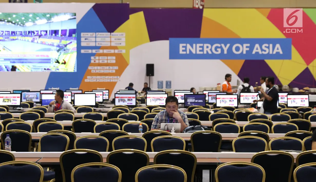 Sejumlah pewarta baik dalam maupun luar negeri beraktivitas di ruang pusat media Asian Games 2018 di JCC, Jakarta, Selasa (14/8). Asian Games 2018 berlangsung hingga 2 September mendatang. (Liputan6.com/Helmi Fithriansyah)