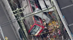 Pandangan dari udara menunjukkan kereta tergelincir setelah menabrak truk di Yokohama, Prefektur Kanagawa, Jepang, Kamis (5/9/2019). Separuh rangkaian kereta anjlok dari rel dan  bagian kaca pada ruang masinis pecah. (JIJI PRESS/AFP)