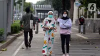 Warga mengenakan masker berjalan di pedestrian Jalan Jenderal Sudirman, Jakarta, Minggu (18/10/2020). Gubernur DKI Jakarta Anies Baswedan menyatakan penggunaan masker oleh masyarakat Jakarta baru mencapai 70 persen dan harus ditingkatkan menjadi 85 persen . (Liputan6.com/Helmi Fithriansyah)