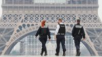 Polisi menyisir area lapangan Esplanade du Trocadero dekat Menara Eiffel saat lockdown di Paris, Prancis, Rabu (18/3/2020). Sampai Selasa (17/3/2020), Prancis memiliki 6.633 kasus virus corona COVID-19 dengan 148 kematian. (Ludovic MARIN/AFP)