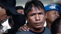 Tersangka kasus perampokan dan pembunuhan di Pulomas, Jakarta Timur, Ridwan Sitorus tiba di Bandara Halim Perdana Kusumah, Minggu (1/1). Ia ditangkap oleh aparat gabungan di sebuah pul bus di Medan, Sumatera Utara. (Liputan6.com/Faizal Fanani)