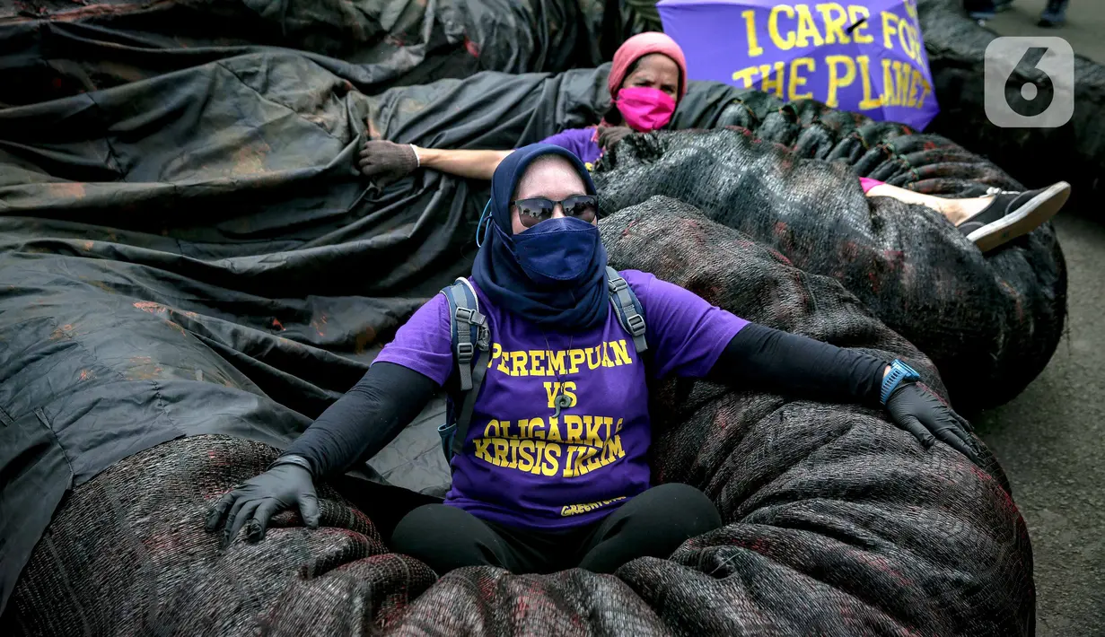 Sejumlah massa aksi berada di antara replika gurita raksasa oligarki saat aksi di Patung Kuda, Jakarta, Selasa (8/3/2022). Aksi tersebut untuk memperingati Hari Perempuan Internasional serta menuntut pengesahan RUU TPKS yang partisipatif dalam pembahasan dan pro korban. (Liputan6.com/Faizal Fanani)