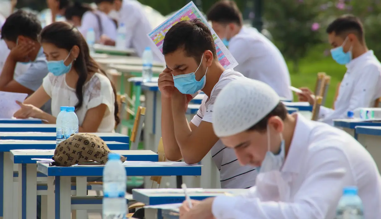 Para siswa Uzbekistan mengikuti ujian masuk luar ruangan, di tengah pandemi COVID-19 yang sedang melanda, di Tashkent pada Rabu (2/9/2020). (Photo by Yuri KORSUNTSEV / AFP)