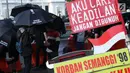 Peserta aksi Kamisan saat aksi di kawasan Silang Monas depan Istana Negara, Jakarta, Kamis (7/2). Seiring aksi Kamisan, JSKK meminta komitmen pemerintah untuk menyelesaikan kasus pelanggaran HAM masa lalu. (Liputan6.com/Helmi Fithriansyah)