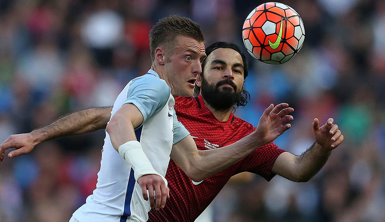 Penyerang Inggris, Jamie Vardy, berusaha melewati gelandang Turki, Selcuk Inan, pada laga persahabatan. Laga persahabatan ini menjadi pertandingan pertama bagi duet Kane-Vardy. (AFP/Scott Heppell)