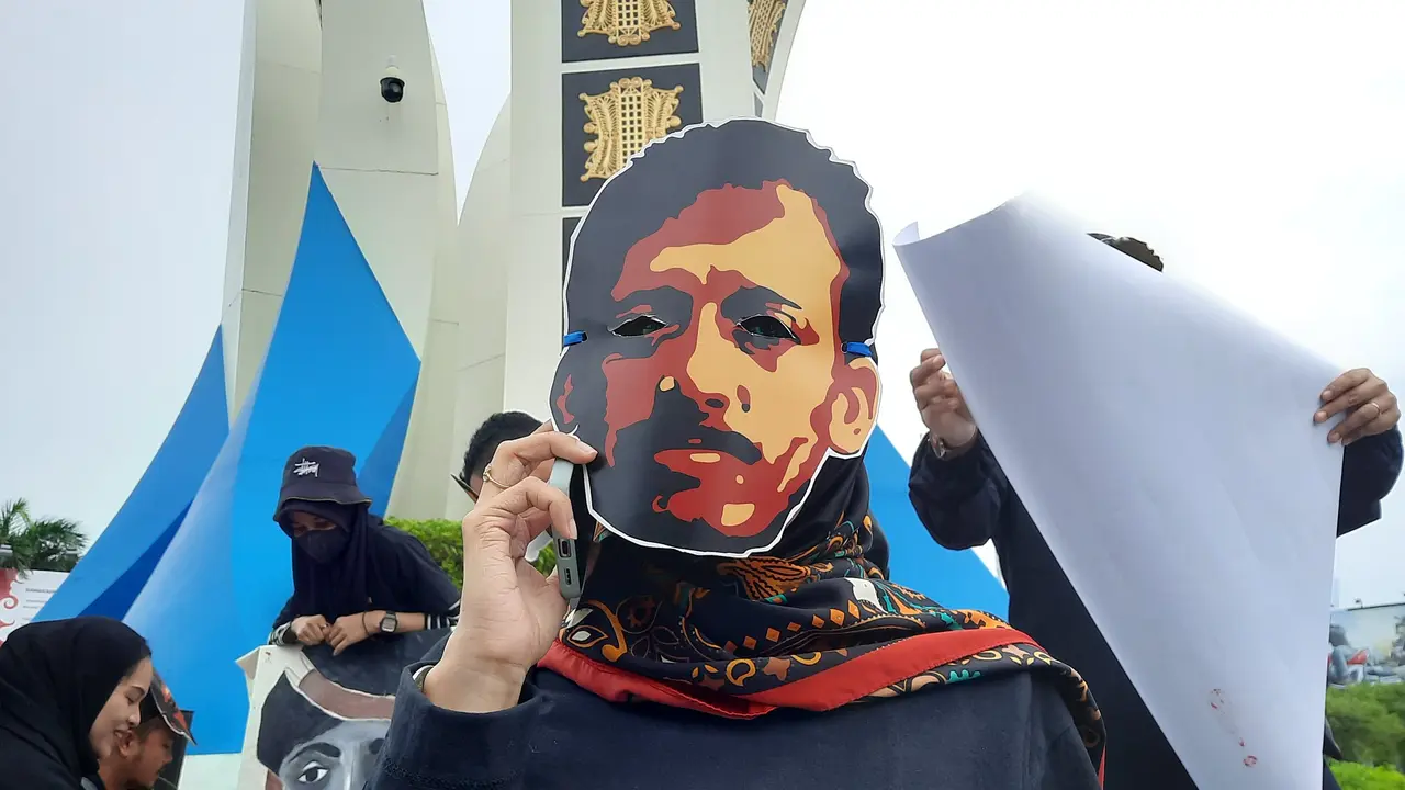 Topeng Munir dalam aksi teatrikal mendesak Komnas HAM tetapkan kasus pembunuhan Munir sebagai pelanggaran HAM berat di Simpang Lima, Banda Aceh, Rabu (7/9/2022), (Liputan6.com/Rino Abonita)