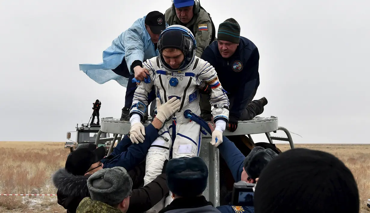 Petugas membantu Kosmonot Rusia, Sergei Volkov untuk keluar dari pesawat kapsul Soyuz yang mendarat di kota Dzhezkazgan, Kazakhstan , (2/3). Para Kosmonot kembali ke Bumi setelah 1 tahun berada di luar angkasa. (REUTERS / Kirill Kudryavtsev)