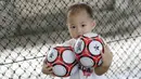 Seorang anak memegang bola saat mengikuti latihan bersama Il Capitano Soccer School di Bintaro, Sabtu (27/10/2018). Kehadiran Il Capitano untuk menjaring dan mengasah pesepak bola cilik untuk berprestasi. (Bola.com/M Iqbal Ichsan)