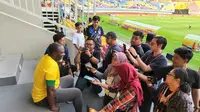 Jacksen F Tiago yang menyaksikan pertandingan babak 16 besar Piala Dunia U-17 2023 antara Ekuador melawan Brasil di Stadion Manahan, Solo, Senin (20/11/2023), mendapatkan serbuan dari penonton untuk berfoto bersama. (Bola.com/Radifa Arsa)