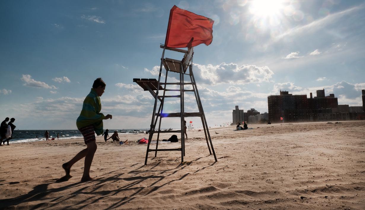 Sebuah kursi penjaga pantai yang kosong berdiri di Coney Island, salah satu tujuan pantai paling populer di wilayah Brooklyn di New York City (29/6/2022). Kota New York menghadapi kekurangan penjaga pantai di kolam renang kota dan pantai tahun ini, memaksa beberapa daerah untuk membatasi waktu berenang. (Spencer Platt/Getty Images/AFP)