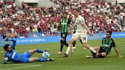 Pemain AC Milan Alexis Saelemaekers (tengah) mencoba peluang mencetak gol saat melawan Sassuolo pada pertandingan sepak bola Liga Italia di Stadion Mapei Reggio Emilia, Italia, 22 Mei 2022. AC Milan juara Liga Italia usai mengalahkan Sassuolo dengan skor 3-0. (AP Photo/Antonio Calanni)