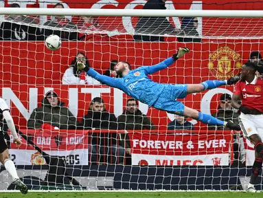 Penjaga gawang Manchester United, David De Gea (tengah), berhasil menghalau bola dari sundulan pemain Fulham dalam babak perempat final Piala FA 2022/2023, Minggu (19/3/2023) malam WIB. Berkat hasil ini, Manchester United pun berhak melenggang ke babak semifinal untuk menghadapi Brighton di Wembley. (AFP/Paul Ellis)