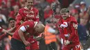Pelatih Liverpool, Arne Slot dismprot oleh Harvey Eliott (kanan) dan Virgil van Dijk (kiri) saat merayakan gelar juara Liga Inggris 2024/2025 setelah mengalahkan Tottenham Hotspur di Anfield, Liverpool, Inggris, Minggu (27/04/2025). (AFP/Paul Ellis)