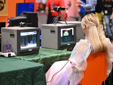 Seorang pengunjung memainkan permainan retro di pameran video game Gamescom di Cologne, Jerman bagian barat pada 23 Agustus 2023. (AFP/Ina Fassbeder)