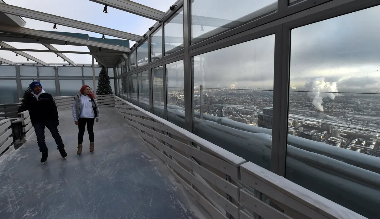 Keseruan pengunjung bermain ice skating di arena ski lantai teratas pusat bisnis Oko Tower di Moskow, Rusia, Kamis (15/12). Arena ski yang berada di ketinggian 354 meter ini diklaim menjadi yang tertinggi di Eropa. (VASILY MAXIMOV/AFP)