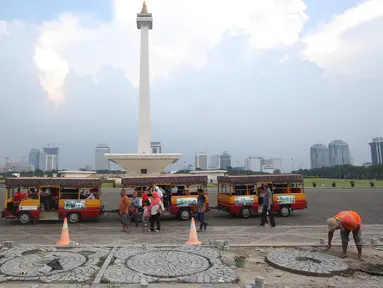 Para pekerja mengganti batu pelataran yang rusak di kawasan Monas, Jakarta, Kamis (10/11). Hal tersebut dilakukan untuk menjaga kawasan Monas agar tetap terawat dan nyaman bagi pengunjung. (Liputan6.com/Immanuel Antonius)