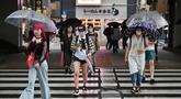 Orang-orang menyeberang di bawah rel kereta api selama hujan yang terisolasi di distrik Akihabara Tokyo (13/8/2022). Hujan lebat yang dibawa oleh Badai Tropis Meari melanda daerah tersebut. (AFP/ Richard A. Brooks)