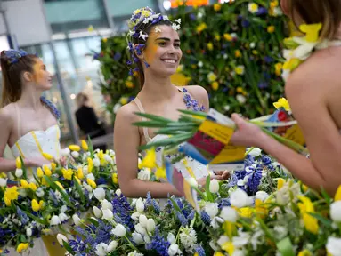 Sejumlah model memakai gaun yang dihiasi dengan bunga saat pameran bunga Keukenhof di Central Station di Utrecht, Belanda, (29/3). Pameran ini menghadirkan sekitar 20.000 bunga musim semi. (AP Photo / Peter Dejong)