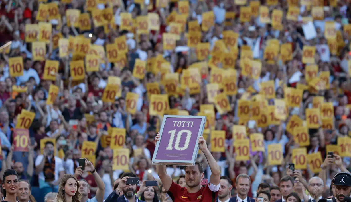 Francesco Totti mengangkat nomor seragam yang dipakainya, usai pertandingan antara AS Roma dan Genoa di Stadion Olimpico, Minggu (28/5). Setelah 25 tahun membela AS Roma, Totti mengakhiri kiprahnya di sepak bola profesional (AP Photo/Alessandra Tarantino)