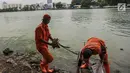 Pasukan oranye mengumpulkan sampah dan daun kering di pinggiran Danau Sunter, Jakarta, Rabu (27/12). Kegiatan bersih-bersih ini dilakukan terkait rencana Pemkot Jakarta Utara menggelar perayaan tahun baru di Danau tersebut. (Liputan6.com/Faizal Fanani)