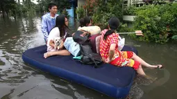 Warga menggunakan kasur karet ketika berusaha keluar dari pemukiman mereka yang terendam banjir di kawasan Periuk, Tangerang, Banten, Selasa (10/2). (ANTARA FOTO/Rivan Awal Lingga)