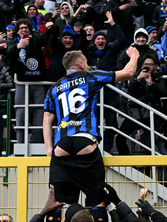Pemain Inter Milan, Davide Frattesi memanjat pagar saat melakukan selebrasi setelah mencetak gol kemenangan ke gawang Hellas Verona pada laga lanjutan Liga Italia 2023/2024 di Giuseppe-Meazza Stadium, Milan, Italia, Sabtu (07/01/2023) dini hari WIB. (AFP/Gabriel Bouys)