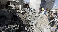 Warga Yaman berdiri di puing-puing rumah yang hancur akibat serangan udara di dekat Kota Sanaa. (Reuters/Khaled Abdullah)