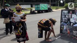 Demonstran melakukan aksi teatrikal saat unjuk rasa di kawasan Bundaran Patung Kuda Arjuna Wijaya, Jakarta, Senin (21/6/2021). Aksi yang dilakukan bertepatan dengan ulang tahun Presiden Joko Widodo ini sebagai bentuk kecaman dan penolakan terhadap revisi UU Minerba. (Liputan6.com/Angga Yuniar)