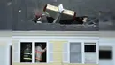 Petugas memeriksa lokasi jatuhnya pesawat ringan bermesin satu yang menabrak atap kondominium di Methuen, Massachusetts, (1/3). Pesawat ini terbang dari Bandara Lawrence Municipal menyeberangi Sungai Merrimack. (AP/Elise Amendola)
