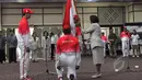 Ketua KOI, Rita Subowo (kanan) bersiap menyerahkan Bendera Merah Putih kepada CDM kontingen Indonesia, Taufik Hidayat (kiri) saat acara Pengukuhan dan Pelepasan Kontingen untuk SEA Games 2015 di Senayan, Jakarta (25/5/2015). (Liputan6.com/Andrian M Tunay)