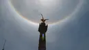 Fenomena halo matahari dengan latar depan monumen Malaikat Kemerdekaan di pusat kota Mexico City, Sabtu (7/7). Fenomena halo matahari terjadi karena pembiasan kristal es yang berada di sekitar Matahari yang membentuk semacam pelangi. (AP/Anthony Vazquez)