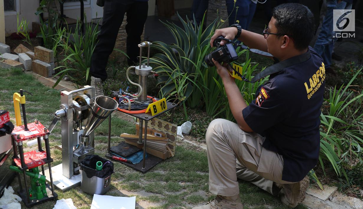 Petugas melakukan olah TKP barang bukti alat pencetak pil ekstasi di sebuah perumahan di Kawasan Pondok Rajeg, Cibinong, Jawa Barat, Senin (24/9). Polisi juga menahan tiga tersangka dan sejumlah barang bukti terkait. (Liputan6.com/Helmi Fithriansyah)