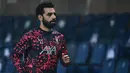 Foto pada 3 November 2020 menunjukkan gelandang Liverpool, Mohamed Salah melakukan pemanasan jelang pertandingan Liga Champions UEFA vs Atalanta Bergamo di stadion Atalanta. Federasi Sepak Bola Mesir melaporkan, Jumat (13/11/2020), Mohamed Salah dinyatakan positif Covid-19. (MIGUEL MEDINA/AFP)