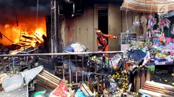 Petugas memindahkan barang-barang di sekitar lokasi kebakaran di Pasar Kebayoran Lama, Jakarta, Selasa (13/6). Tidak ada korban jiwa dalam kebakaran tersebut. (Liputan6.com/Johan Tallo)